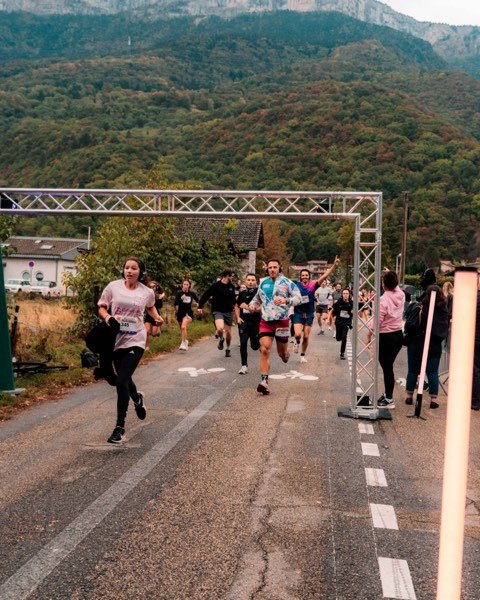 Les coureurs passent sous l'arche, montagnes en arrière-plan