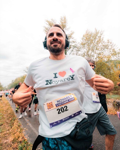 Un coureur souriant en t-shirt « I love Noyarey », dossard 202
