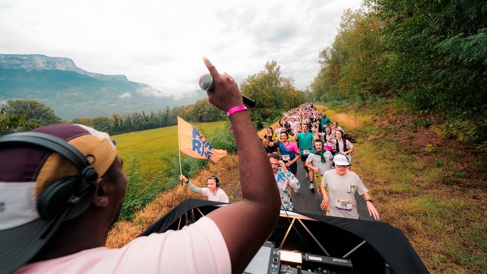 Le DJ sur le pick-up guide les coureurs, falaises en arrière-plan